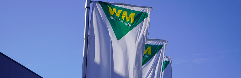 Vlaggen van WM Automaterialen wapperen in de wind